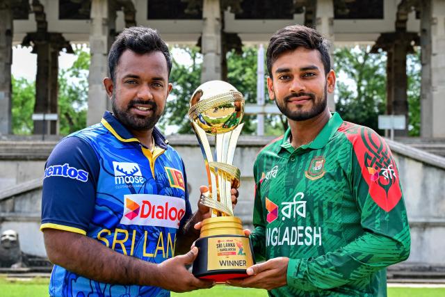 Sri Lanka's captain Charith Asalanka (L) poses with the trophy alongside his Bangladesh counterpart Mehidy Hasan Miraz on the eve of their first one-day international (ODI) cricket match in Colombo on July 1, 2025. (Photo by Ishara S. KODIKARA / AFP)