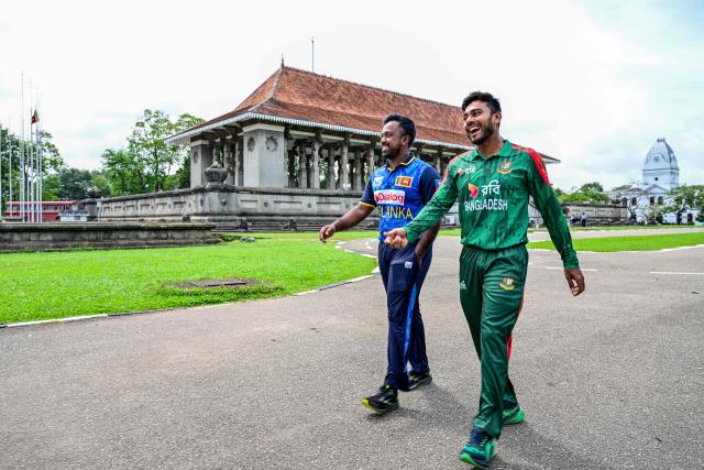 Sri Lanka's captain Charith Asalanka (L) walks alongside his Bangladesh counterpart Mehidy Hasan Miraz as they share a laugh during the unveiling of the trophy on the eve of their first one-day international (ODI) cricket match in Colombo on July 1, 2025. (Photo by Ishara S. KODIKARA / AFP)