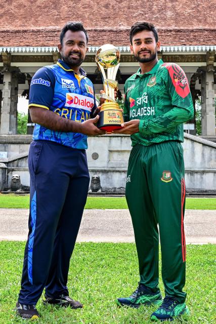 Sri Lanka's captain Charith Asalanka (L) poses with the trophy alongside his Bangladesh counterpart Mehidy Hasan Miraz on the eve of their first one-day international (ODI) cricket match in Colombo on July 1, 2025. (Photo by Ishara S. KODIKARA / AFP)