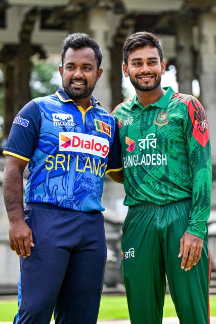 Sri Lanka's captain Charith Asalanka (L) poses with his Bangladesh counterpart Mehidy Hasan Miraz on the eve of their first one-day international (ODI) cricket match in Colombo on July 1, 2025. (Photo by Ishara S. KODIKARA / AFP)