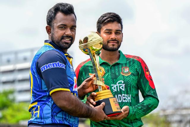 Sri Lanka's captain Charith Asalanka (L) poses with the trophy alongside his Bangladesh counterpart Mehidy Hasan Miraz on the eve of their first one-day international (ODI) cricket match in Colombo on July 1, 2025. (Photo by Ishara S. KODIKARA / AFP)