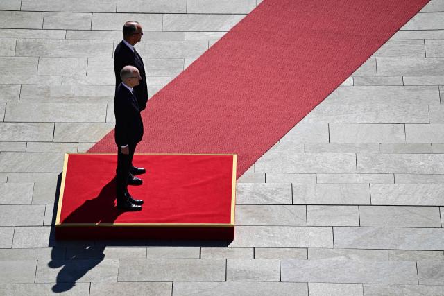 German Chancellor Friedrich Merz (background) and Luxembourg's Prime Minister Luc Frieden listen to their national anthems before reviewing a military honor guard during an official welcome ceremony in front of the Chancellery in Berlin on July 1, 2025. (Photo by John MACDOUGALL / AFP)
