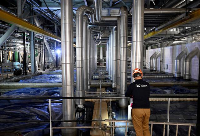 (FILES) A technician performs checks in the ice storage room of the air-conditioning and heating network managed by Idex, in Paris' business district of La Defense that spreads over the southern part of Courbevoie on June 16, 2022. Temperatures in France are expected to hit a peak, according to the Meteo France weather agency, with some areas expected to soar beyond 40 degrees Celsius (104 degrees Fahrenheit). (Photo by Emmanuel DUNAND / AFP)