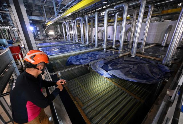 (FILES) A technician performs checks in the ice storage room of the air-conditioning and heating network managed by Idex, in Paris' business district of La Defense that spreads over the southern part of Courbevoie on June 16, 2022. Temperatures in France are expected to hit a peak, according to the Meteo France weather agency, with some areas expected to soar beyond 40 degrees Celsius (104 degrees Fahrenheit). (Photo by Emmanuel DUNAND / AFP)