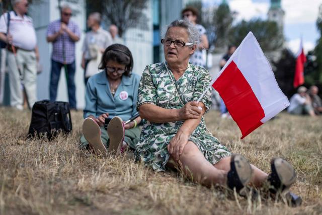 Supporters of Karol Nawrocki, president elect supported by Poland's right-wing Law and Justice (PiS) party, wait in front of the Supreme Court building in Warsaw on July 1, 2025 for the announcement of the ruling on the validity of the presidential election. (Photo by Wojtek RADWANSKI / AFP)