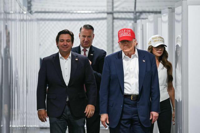 US President President Donald Trump (2R), Florida Governor Ron DeSantis (L), and Secretary of Homeland Security Kristi Noem (R) tour a migrant detention center, dubbed "Alligator Alcatraz," located at the site of the Dade-Collier Training and Transition Airport in Ochopee, Florida on July 1, 2025. President Trump is visiting a migrant detention center in a reptile-infested Florida swamp dubbed "Alligator Alcatraz." Trump will attend the opening of the 5,000-bed facility -- located at an abandoned airfield in the Everglades wetlands -- part of his expansion of deportations of undocumented migrants, his spokeswoman said. (Photo by ANDREW CABALLERO-REYNOLDS / AFP)