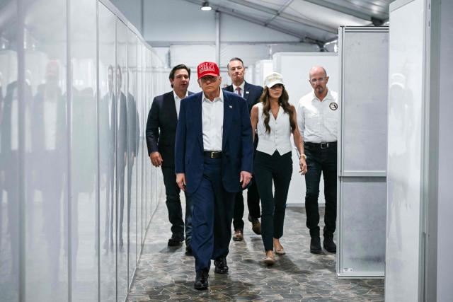 US President President Donald Trump (2L), Florida Governor Ron DeSantis (L), and Secretary of Homeland Security Kristi Noem (2R) walk through a medical facility section as they tour a migrant detention center, dubbed "Alligator Alcatraz," located at the site of the Dade-Collier Training and Transition Airport in Ochopee, Florida on July 1, 2025. President Trump is visiting a migrant detention center in a reptile-infested Florida swamp dubbed "Alligator Alcatraz." Trump will attend the opening of the 5,000-bed facility -- located at an abandoned airfield in the Everglades wetlands -- part of his expansion of deportations of undocumented migrants, his spokeswoman said. (Photo by ANDREW CABALLERO-REYNOLDS / AFP)