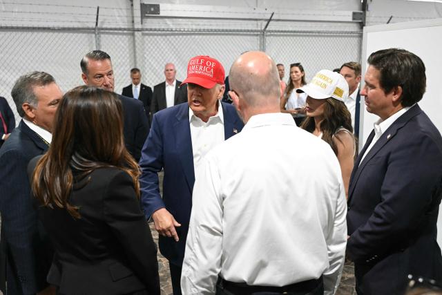 US President President Donald Trump (C), Florida Governor Ron DeSantis (R), and Secretary of Homeland Security Kristi Noem (2nd-R) walk through a medical facility section as they tour a migrant detention center, dubbed "Alligator Alcatraz," located at the site of the Dade-Collier Training and Transition Airport in Ochopee, Florida on July 1, 2025. President Trump is visiting a migrant detention center in a reptile-infested Florida swamp dubbed "Alligator Alcatraz." Trump will attend the opening of the 5,000-bed facility -- located at an abandoned airfield in the Everglades wetlands -- part of his expansion of deportations of undocumented migrants, his spokeswoman said. (Photo by ANDREW CABALLERO-REYNOLDS / AFP)