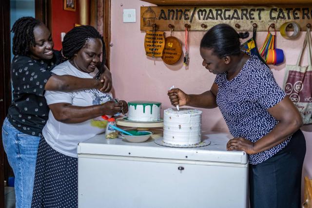 Mary Nakaliika, 24, an adopted daughter of Dr. Anne Merriman and a nurse (L), prepares a cake with other family members for children supported by Hospice Africa Uganda (HAU) at her home in Kampala, on June 26, 2025. Hospice Africa Uganda (HAU), founded in 1993 by Dr Anne Merriman, brought holistic end-of-life care to Uganda at a time when it was offered in only three African countries.
By the time Merriman died in May 2025, aged 90, she had treated more than 40,000 patients in Uganda and her model had spread to 37 African countries. (Photo by Badru Katumba / AFP)