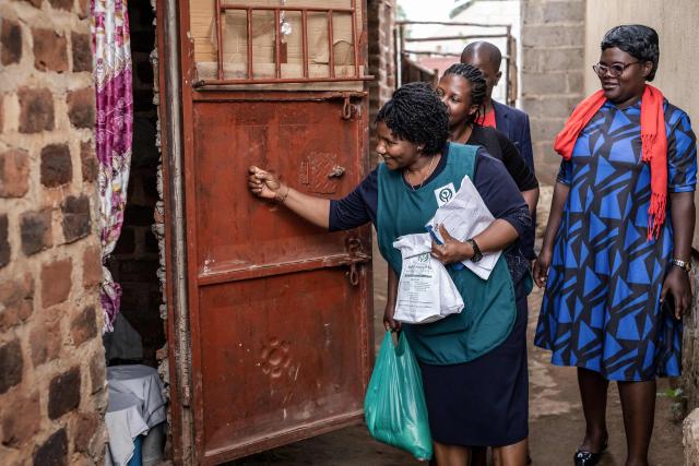 Jane Mwesige (C), a nurse at Hospice Africa Uganda (HAU), knocks the door of patient Jonathan Luzige's home while carrying morphine and other medicines for a home visit in Nabbingo, on June 26, 2025. Hospice Africa Uganda (HAU), founded in 1993 by Dr Anne Merriman, brought holistic end-of-life care to Uganda at a time when it was offered in only three African countries.
By the time Merriman died in May 2025, aged 90, she had treated more than 40,000 patients in Uganda and her model had spread to 37 African countries. (Photo by Badru Katumba / AFP)
