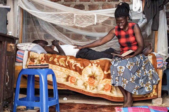 Josephine Namwanjje (R), 28, prays while holding a Bible for her brother Jonathan Luzige, a colon cancer patient, at their home in Nabbingo, on June 26, 2025. Hospice Africa Uganda (HAU), founded in 1993 by Dr Anne Merriman, brought holistic end-of-life care to Uganda at a time when it was offered in only three African countries.
By the time Merriman died in May 2025, aged 90, she had treated more than 40,000 patients in Uganda and her model had spread to 37 African countries. (Photo by Badru Katumba / AFP)