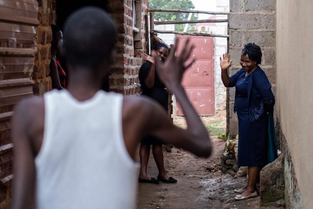 Jane Mwesige (R), a nurse at Hospice Africa Uganda (HAU), waves to patient Jonathan Luzige as she leaves his home following a visit in Nabbingo, on June 26, 2025. Hospice Africa Uganda (HAU), founded in 1993 by Dr Anne Merriman, brought holistic end-of-life care to Uganda at a time when it was offered in only three African countries.
By the time Merriman died in May 2025, aged 90, she had treated more than 40,000 patients in Uganda and her model had spread to 37 African countries. (Photo by Badru Katumba / AFP)