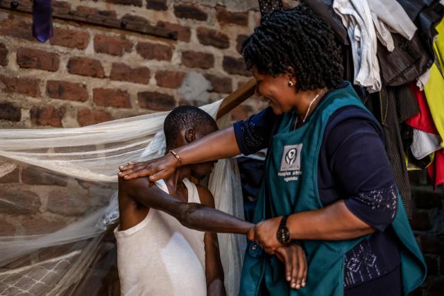 Jane Mwesige, a nurse at Hospice Africa Uganda (HAU), massages the arms of patient Jonathan Luzige during a home visit in Nabbingo, on June 26, 2025. Hospice Africa Uganda (HAU), founded in 1993 by Dr Anne Merriman, brought holistic end-of-life care to Uganda at a time when it was offered in only three African countries.
By the time Merriman died in May 2025, aged 90, she had treated more than 40,000 patients in Uganda and her model had spread to 37 African countries. (Photo by Badru Katumba / AFP)