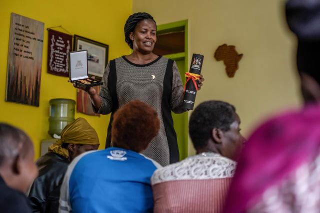 Prossy Nkayanga (C), Executive Director of Hospice Africa Uganda (HAU), shows patients the Hero's Medal awarded to Dr. Anne Merriman by the President of Uganda at the hospice in Kampala, on June 24, 2025. Hospice Africa Uganda (HAU), founded in 1993 by Dr Anne Merriman, brought holistic end-of-life care to Uganda at a time when it was offered in only three African countries.
By the time Merriman died in May 2025, aged 90, she had treated more than 40,000 patients in Uganda and her model had spread to 37 African countries. (Photo by Badru Katumba / AFP)