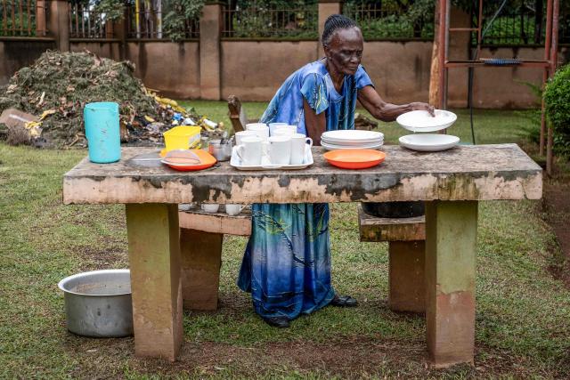 Eron Nakaggwa, 84, the oldest volunteer at Hospice Africa Uganda (HAU), washes dishes while doing house chores at the hospice in Kampala, on June 24, 2025. Hospice Africa Uganda (HAU), founded in 1993 by Dr Anne Merriman, brought holistic end-of-life care to Uganda at a time when it was offered in only three African countries.
By the time Merriman died in May 2025, aged 90, she had treated more than 40,000 patients in Uganda and her model had spread to 37 African countries. (Photo by Badru Katumba / AFP)