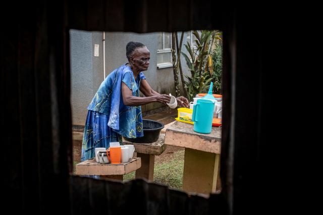 Eron Nakaggwa, 84, the oldest volunteer at Hospice Africa Uganda (HAU), washes dishes while doing house chores at the hospice in Kampala, on June 24, 2025. Hospice Africa Uganda (HAU), founded in 1993 by Dr Anne Merriman, brought holistic end-of-life care to Uganda at a time when it was offered in only three African countries.
By the time Merriman died in May 2025, aged 90, she had treated more than 40,000 patients in Uganda and her model had spread to 37 African countries. (Photo by Badru Katumba / AFP)