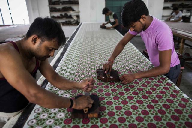 (FILES) In this photograph taken on June 3, 2022, workers use the hand block printing technique on a cotton fabric at the workshop of Indian naturalized textile designer Brigitte Singh in Amber, on the outskirts of Jaipur in India's Rajasthan state. Indian exporters are anxiously eyeing the possible reintroduction of Donald Trump's punishing tariffs on the second week of July 2025, though many hold out hope for a last-minute reprieve. The US president's April 2 "Liberation Day" announcement of swingeing levies on dozens of key trading partners sent shockwaves through capitals before he announced a pause for negotiations, which ends on July 9, 2025. New Delhi and Washington have been locked in multiple rounds of talks, with hopes for an interim pact to avert the 26 percent "reciprocal" tolls meted out to India. (Photo by Xavier GALIANA / AFP)