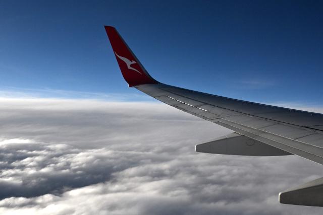 (FILES) This picture taken on June 29, 2025 shows a Qantas plane flying over Perth. Australian airline Qantas said on July 2, 2025 it was investigating a "significant" cyberattack, after hackers infiltrated a system containing sensitive data on six million customers. (Photo by SAEED KHAN / AFP)