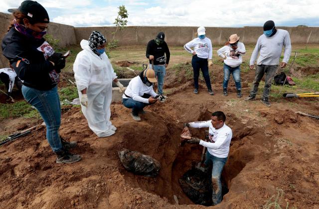 Members of the "Guerreros Buscadores" collective find human remains in a clandestine grave in Zapopan, Jalisco State, Mexico, on July 1, 2025, where the public prosecutor's office had concluded its search efforts. On June 26, Mexican authorities discovered the bodies of 34 people in a mass grave in a western region wracked by criminal violence, the state prosecutor's office said. The remains were found during construction work in Zapopan in Jalisco state, home to one of the country's most powerful drug cartels, prosecutor Salvador Gonzalez told a news conference. (Photo by AFP)