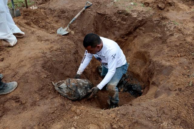 A member of the "Guerreros Buscadores" collective finds human remains in a clandestine grave in Zapopan, Jalisco State, Mexico, on July 1, 2025, where the public prosecutor's office had concluded its search efforts. On June 26, Mexican authorities discovered the bodies of 34 people in a mass grave in a western region wracked by criminal violence, the state prosecutor's office said. The remains were found during construction work in Zapopan in Jalisco state, home to one of the country's most powerful drug cartels, prosecutor Salvador Gonzalez told a news conference. (Photo by AFP)