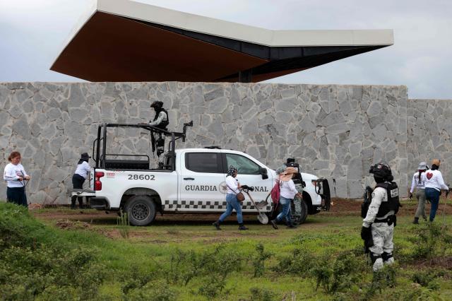 Members of the "Guerreros Buscadores" collective, guarded by National Guard personnel, search human remains in a clandestine grave in Zapopan, Jalisco State, Mexico, on July 1, 2025, where the public prosecutor's office had concluded its search efforts. On June 26, Mexican authorities discovered the bodies of 34 people in a mass grave in a western region wracked by criminal violence, the state prosecutor's office said. The remains were found during construction work in Zapopan in Jalisco state, home to one of the country's most powerful drug cartels, prosecutor Salvador Gonzalez told a news conference. (Photo by AFP)