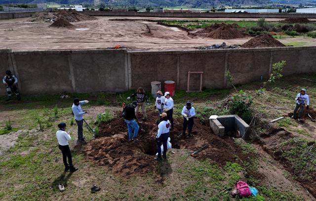 Aerial view of members of the "Guerreros Buscadores" collective, guarded by National Guard personnel, searching human remains in a clandestine grave in Zapopan, Jalisco State, Mexico, on July 1, 2025, where the public prosecutor's office had concluded its search efforts. On June 26, Mexican authorities discovered the bodies of 34 people in a mass grave in a western region wracked by criminal violence, the state prosecutor's office said. The remains were found during construction work in Zapopan in Jalisco state, home to one of the country's most powerful drug cartels, prosecutor Salvador Gonzalez told a news conference. (Photo by AFP)