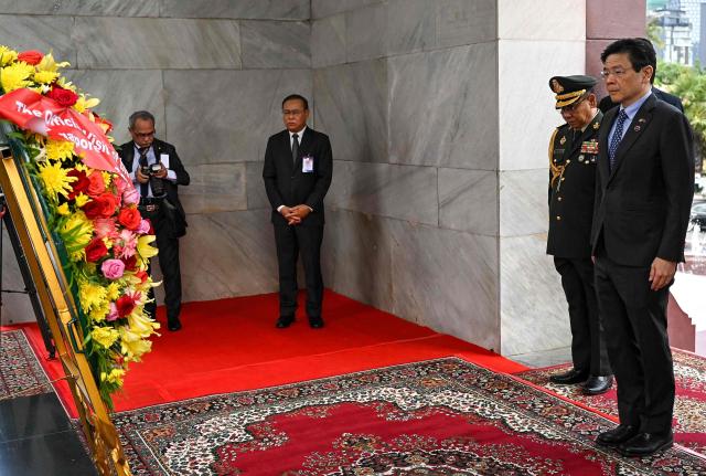 Singapore’s Prime Minister Lawrence Wong (R) pays his respects at the Independence Monument in Phnom Penh on July 2, 2025. (Photo by TANG CHHIN Sothy / AFP)