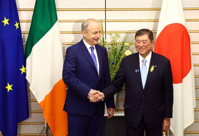 Japanese Prime Minister Shigeru Ishiba (R) shakes hands with Irish Prime Minister Micheal Martin before their summit talks at Ishiba's official residence in Tokyo on July 2, 2025. (Photo by ISSEI KATO / POOL / AFP)