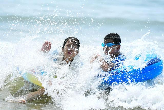 Children play on a beach in Qingdao, in eastern China's Shandong province on July 1, 2025. (Photo by AFP) / China OUT