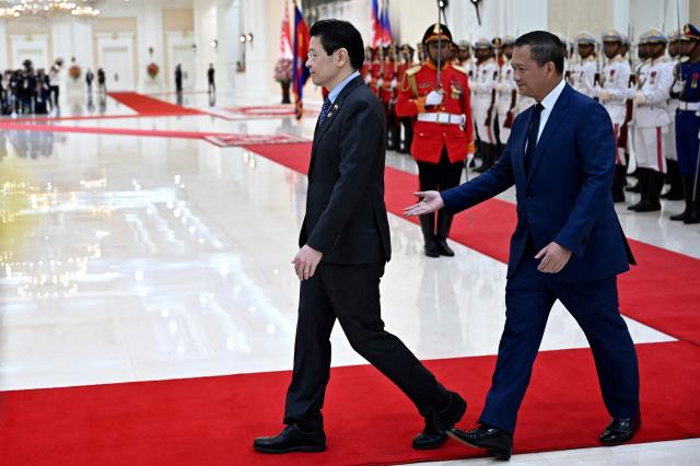 Cambodia's Prime Minister Hun Manet (R) welcomes Singapore’s Prime Minister Lawrence Wong at the Peace Palace in Phnom Penh on July 2, 2025. (Photo by TANG CHHIN Sothy / AFP)