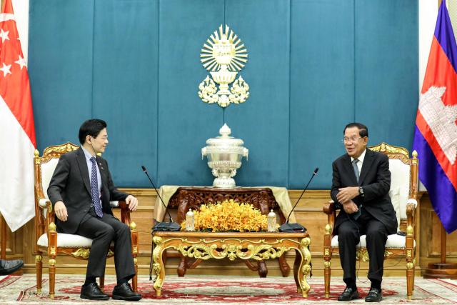 This pool photo taken and released on July 2, 2025 by Agence Kampuchea Presse (AKP) shows Cambodia's Senate President Hun Sen (R) speaking to Singapore's Prime Minister Lawrence Wong (L) during a meeting at the Senate in Phnom Penh. (Photo by -STR / POOL / AFP)