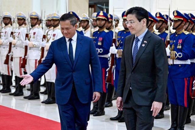 Cambodia's Prime Minister Hun Manet (L) welcomes Singapore's Prime Minister Lawrence Wong (R) at the Peace Palace in Phnom Penh on July 2, 2025. (Photo by TANG CHHIN Sothy / AFP)