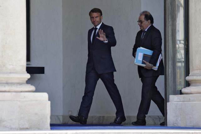France's President Emmanuel Macron (C) and his general secretary Emmanuel Moulin leave after the weekly cabinet meeting at the Elysee palace in Paris, on July 2, 2025. (Photo by Ludovic MARIN / AFP)