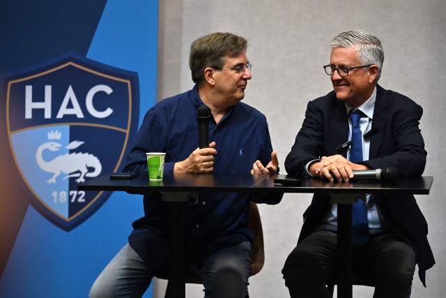 HAC football club owner Vincent Volpe (L) flanked by US co-founder of Blue Crow Sports Group, Jeff Luhnow, gives a media press conference, at the Oceane Stadium, in Le Havre, northwestern France, on July 2, 2025. On June 27, 2025, Vincent Volpe sold HAC to Blue Crow Sports Group. The American group, which already owns several clubs, thus becomes the new owner of the oldest French club. (Photo by Lou BENOIST / AFP)
