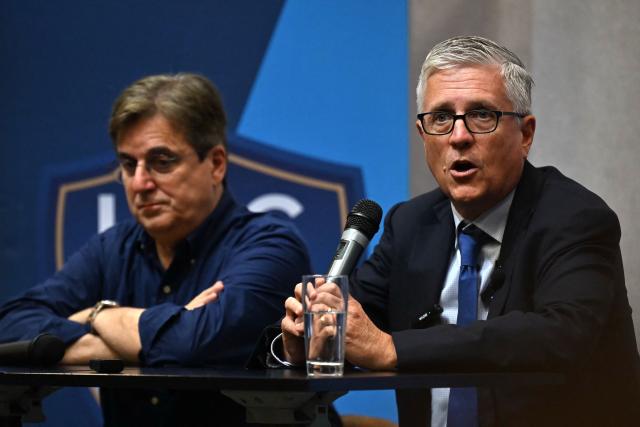 HAC football club owner Vincent Volpe (L) flanked by US co-founder of Blue Crow Sports Group, Jeff Luhnow, gives a media press conference, at the Oceane Stadium, in Le Havre, northwestern France, on July 2, 2025. On June 27, 2025, Vincent Volpe sold HAC to Blue Crow Sports Group. The American group, which already owns several clubs, thus becomes the new owner of the oldest French club. (Photo by Lou BENOIST / AFP)