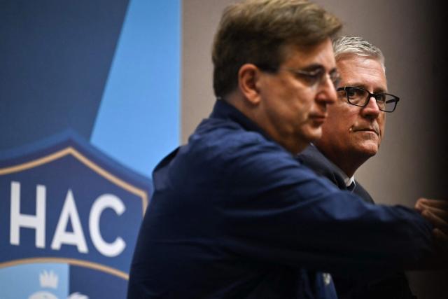 HAC football club owner Vincent Volpe (L) flanked by US co-founder of Blue Crow Sports Group, Jeff Luhnow, gives a media press conference, at the Oceane Stadium, in Le Havre, northwestern France, on July 2, 2025. On June 27, 2025, Vincent Volpe sold HAC to Blue Crow Sports Group. The American group, which already owns several clubs, thus becomes the new owner of the oldest French club. (Photo by Lou BENOIST / AFP)