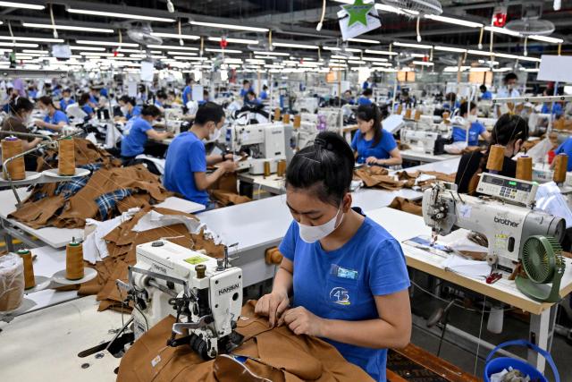 Workers stitch apparels at a garment factory in Vietnam's Thai Nguyen Province on July 2, 2025. Vietnam, a global manufacturing hub dependent on exports, faces a potential "reciprocal tariff" hike from 10 to 46 percent without a US trade deal. (Photo by Nhac NGUYEN / AFP)