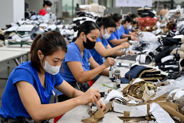Workers number fabric at a garment factory in Vietnam's Thai Nguyen Province on July 2, 2025. Vietnam, a global manufacturing hub dependent on exports, faces a potential "reciprocal tariff" hike from 10 to 46 percent without a US trade deal. (Photo by Nhac NGUYEN / AFP)