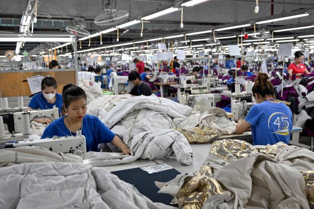 Workers stitch apparels at a garment factory in Vietnam's Thai Nguyen Province on July 2, 2025. Vietnam, a global manufacturing hub dependent on exports, faces a potential "reciprocal tariff" hike from 10 to 46 percent without a US trade deal. (Photo by Nhac NGUYEN / AFP)