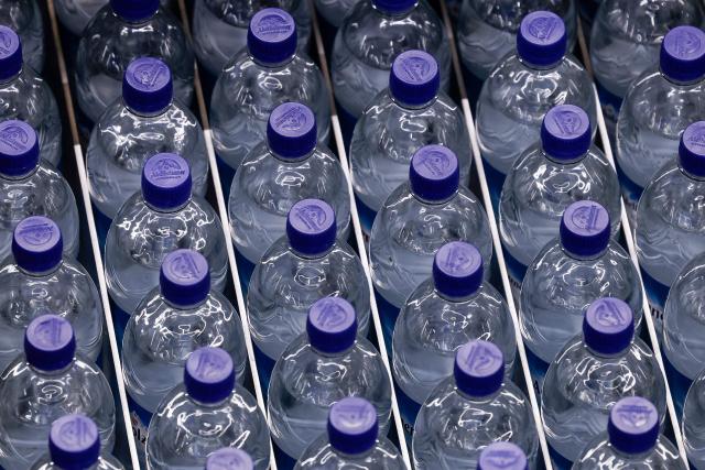 Water bottles are moved on a production line at the Adelholzener water bottling plant in Bad Adelholzen, southern Germany, July 2, 2025. Adelholzener Alpenquellen GmbH is the largest mineral spring in Bavaria. The Congregation of the Sisters of Mercy of St Vincent de Paul is the one hundred percent shareholder of the company. More than 580 million mineral water products are filled up every year. This is the company's 10th plant in total, which opened today, and it can now produce 36,000 more bottles per hour. (Photo by Michaela STACHE / AFP)