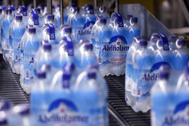 Water bottles are moved on a production line at the Adelholzener water bottling plant in Bad Adelholzen, southern Germany, July 2, 2025. Adelholzener Alpenquellen GmbH is the largest mineral spring in Bavaria. The Congregation of the Sisters of Mercy of St Vincent de Paul is the one hundred percent shareholder of the company. More than 580 million mineral water products are filled up every year. This is the company's 10th plant in total, which opened today, and it can now produce 36,000 more bottles per hour. (Photo by Michaela STACHE / AFP)