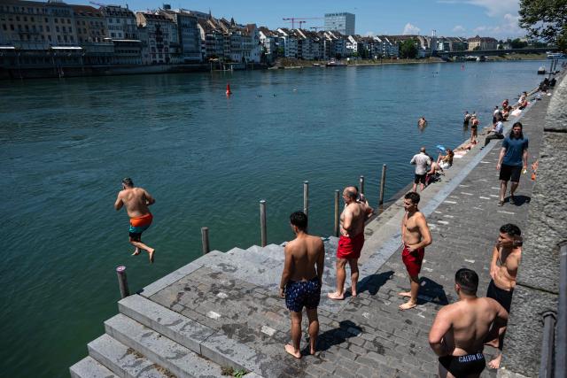 People dive into the Rhine River in Basel on July 2, 2025, as a heatwave hits Europe. (Photo by Miguel MEDINA / AFP)