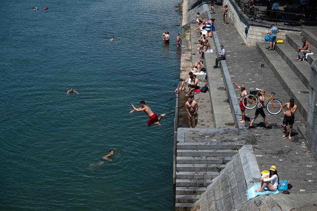 People dive into the Rhine River in Basel on July 2, 2025, as a heatwave hits Europe. (Photo by Miguel MEDINA / AFP)
