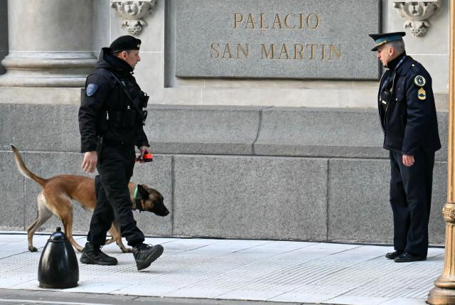 A policeman with a sniffer dog patrols outside the San Martin Palace in Buenos Aires during the Ordinary Meeting of the Common Market Council (CMC) on July 2, 2025, within the framework of the 66th Summit of Leaders of Mercosur and Associated States. Leaders of South America's Mercosur bloc will hold two days of talks in Buenos Aires, focused on a massive trade deal with the European Union being blocked by France. (Photo by Luis ROBAYO / AFP)
