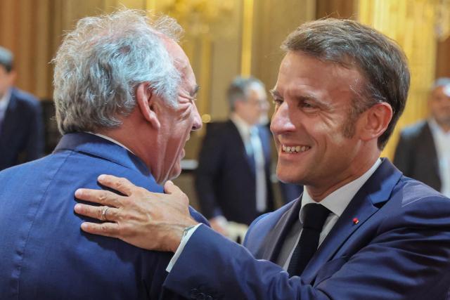 France's Prime Minister Francois Bayrou (L) shakes hands with France's President Emmanuel Macron as they attend a summit on New Caledonia at the Elysee Palace in Paris on July 2, 2025. After months of “patient work” and three return trips to New Caledonia, France's Minister of Overseas is hoping to reach a compromise between independentists and loyalists at the “summit” that begins on July 2. (Photo by Ludovic MARIN / POOL / AFP)