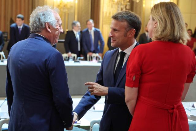 France's Prime Minister Francois Bayrou (L) shakes hands with France's President Emmanuel Macron next to President of the French National Assembly Yael Braun-Pivet as they attend a summit on New Caledonia at the Elysee Palace in Paris on July 2, 2025. After months of “patient work” and three return trips to New Caledonia, France's Minister of Overseas is hoping to reach a compromise between independentists and loyalists at the “summit” that begins on July 2. (Photo by Ludovic MARIN / POOL / AFP)