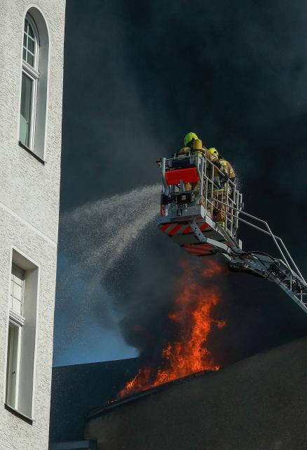 Members of the fire brigade work to extinguish a blaze at a apartment building in Berlin on July 2, 2025. (Photo by Odd ANDERSEN / AFP) / ALTERNATIVE CROP