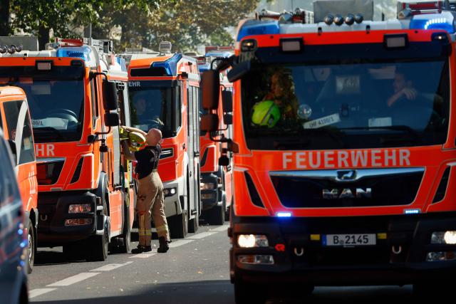 A member of the fire brigade packs a hose as his colleagues continue to extinguish a blaze at a apartment building in Berlin on July 2, 2025. (Photo by Odd ANDERSEN / AFP)
