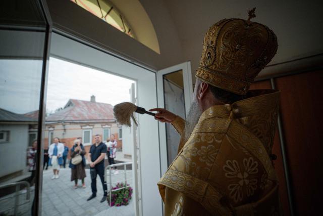 Head of the Orthodox Church of Ukraine, Metropolitan Epiphanius (C), blesses believers during a consecration ceremony of a newly built church in the village of Koviagy, Kharkiv region, on July 2, 2025, amid the Russian invasion of Ukraine. (Photo by Ivan SAMOILOV / AFP)