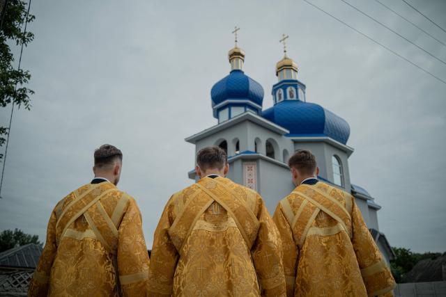Clergymen attend a consecration ceremony of a newly built church in the village of Koviagy, Kharkiv region, on July 2, 2025, amid the Russian invasion of Ukraine. (Photo by Ivan SAMOILOV / AFP)